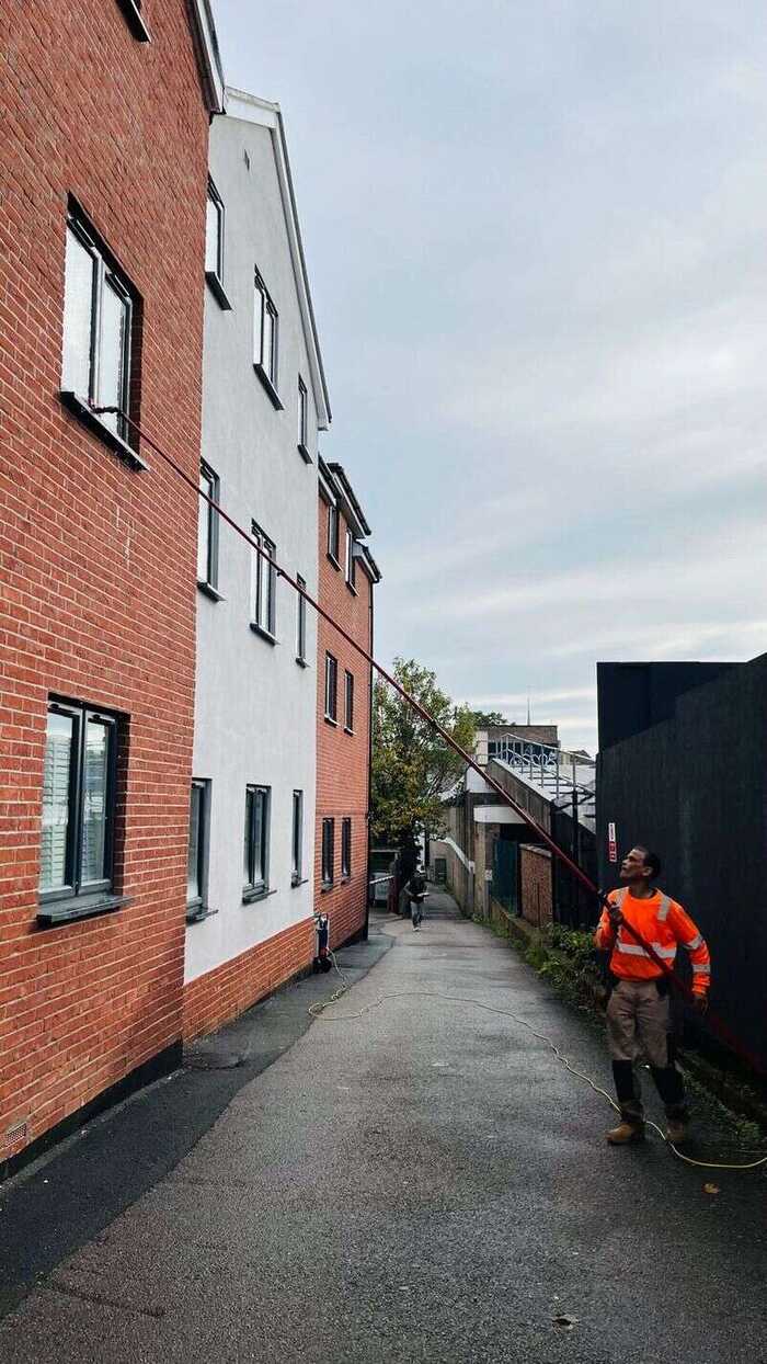 Window cleaner reaching windows on a multi-storey brick building